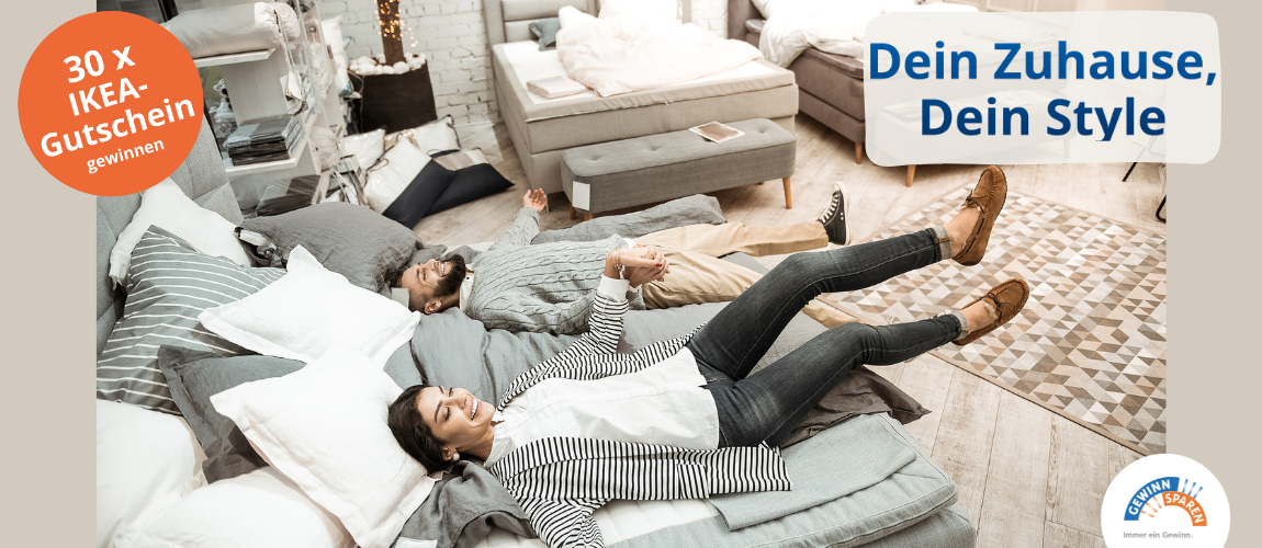 Zwei junge Erwachsene liegen entspannt und lachend nebeneinander auf einem großen grauen Bett in einem Möbelhaus. Um sie herum stehen weitere Sofas und Betten. Links oben ein orangefarbener Kreis mit dem Hinweis „30 x IKEA-Gutschein gewinnen“. Rechts oben der Text „Dein Zuhause, Dein Style“.